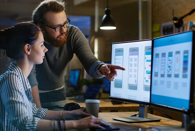 Designers working on a logo on a desktop computer.