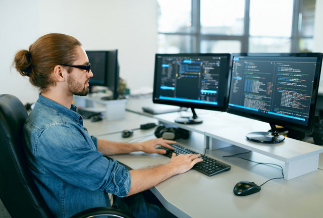 Software developer looking at a screen with source code on it.
