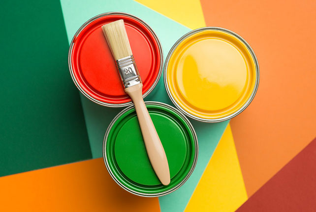 Multicoloured surface with green, red and yellow paint cans.