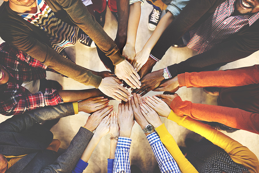 Aerial view of a group of people huddling their hands together