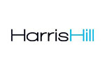 White tile with the words 'Harris Hill' written in black and blue'.